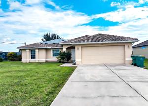 a house with a garage in a yard at Experience Fun Starts Here w Pool & Wifi in Port Charlotte