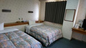 Rúm í herbergi á Handa Station Hotel