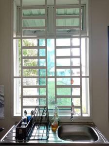 a kitchen sink with a window above it at Sri Keroma Bajandoh Muar Homestay in Muar