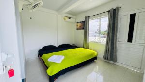 a bedroom with a yellow bed with a window at Keylee's Lodging in San Andrés +13 photos