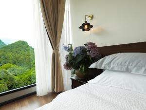 a bedroom with a bed and a window with flowers at 张家界喜屋民宿 in Zhangjiajie