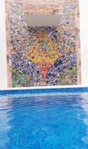 a mosaic wall next to a swimming pool at Casa Girasoles Valladolid Yucatán in Santa Bárbara