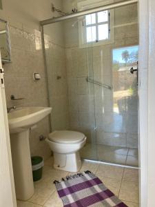 a bathroom with a shower and a toilet and a sink at Pousada Prana Bichinho in Bichinho