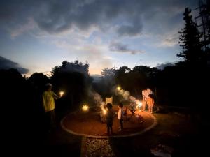 a group of people standing around a fire at night at 一棟貸し別荘 mitt house inn in Numata