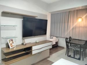 a living room with a large television and a table at Exelente Apart hotel otima localizaçao in Brasilia