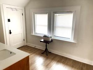a bathroom with two windows and a table with a sink at Cozy Studio Loft Near Downtown in Columbus