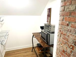 a room with a microwave on a table next to a brick wall at Cozy Studio Loft Near Downtown in Columbus