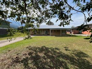 a house with a large yard in front of it at Orchard Lake House - Entire bungalow, 4 rooms, 9 beds, 13 persons in Behrang Hulu