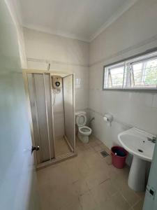 a bathroom with a shower and a toilet and a sink at Orchard Lake House - Entire bungalow, 4 rooms, 9 beds, 13 persons in Behrang Hulu