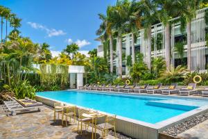 a swimming pool with chairs and a building at Viroth's Hotel in Siem Reap