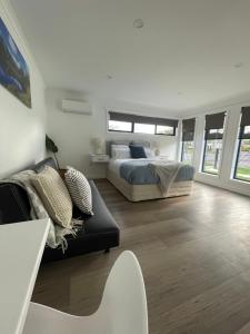 a bedroom with a bed and a couch at Four Square Short Stay Accommodation Railton in Railton