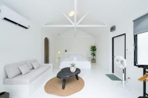 a white living room with a bed and a table at Stunning Pool Villa - In Old Town Chiang Mai Daily Housekeeping in Chiang Mai
