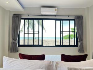 a bedroom with a bed and a view of the beach at Benjamin's Hut in Srithanu +106 photos