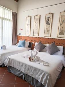 two beds in a room with towels on them at Lanshe Gate in Chung-lan