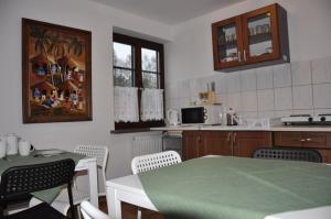 uma cozinha com uma mesa e uma mesa verde e cadeiras em Willa Irys z basenem em Kazimierz Dolny
