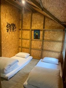 2 camas en una habitación con pared en 忘憂天空民宿, en T'an-nan