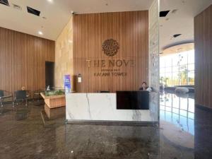 Eine Lobby eines Hotels mit einem Mann, der an einem Schreibtisch sitzt. in der Unterkunft Apartment Nuvasa Bay Nongsa, Kalani 1BR 12th, Sea & Golf View in Telukmataikan
