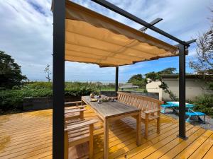 a wooden deck with a wooden pergola at はたご屋ちゅうべ in Taki