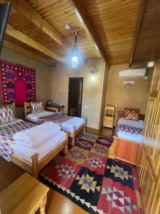 a room with two beds and a rug at Old Palace Hotel in Samarkand