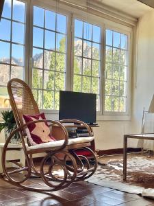 a room with a chair and a desk and windows at Casa Annie in Collbató