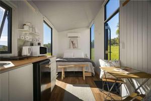 a kitchen and living room with a bed in the background at Tiny Grey Gum by Tiny Away in Glenreagh