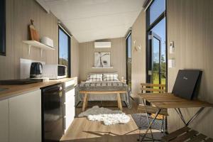 a room with a kitchen and a bedroom with a bed at Tiny Ironbark by Tiny Away in Glenreagh