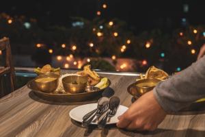 a table with a plate of food and silverware on it at Nepalaya Hotel Thamel 17 Kwabhal in Kathmandu