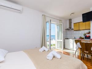 a bedroom with a bed and a kitchen with a view at Apartments Cypress Sea Cove - Comfort Studio Apartment with Balcony and Sea View A1 in Slano