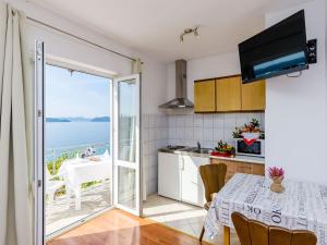 a kitchen with a table and a view of the ocean at Apartments Cypress Sea Cove - Comfort Studio Apartment with Balcony and Sea View A1 in Slano