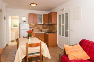 eine Küche und ein Esszimmer mit einem Tisch und einer Couch in der Unterkunft Apartments Stipo - Comfort Two Bedroom Apartment with Balcony and Sea View A2 in Drače + 9 Fotos