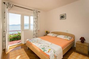 ein Schlafzimmer mit einem Bett und einem großen Fenster in der Unterkunft Apartments Stipo - Comfort Two Bedroom Apartment with Balcony and Sea View A2 in Drače