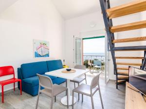 Una sala de estar con un sofá azul y una mesa y sillas. en Apartments Villa Lukas - ''No 12'' Gallery Two Bedroom Apartment with Balcony and Sea View, en Cavtat