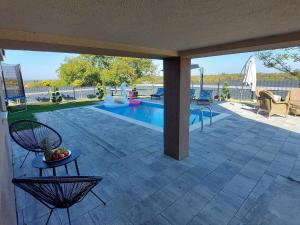 a patio with a pool and a table and chairs at Holiday Home Gra ec - Three Bedroom Holiday Home with swimming pool in Zagreb