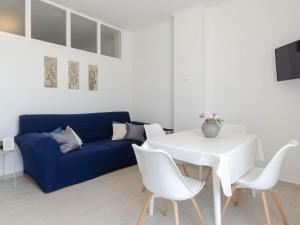 a living room with a blue couch and a white table and chairs at Apartments K & N - One bedroom apartment A2 in Prizba