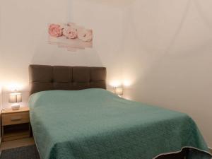 a bedroom with a bed with a green comforter at Apartments K & N - One bedroom apartment A2 in Prizba