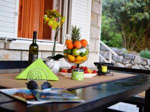ein Tisch mit einer Schale Obst und einer Flasche Wein in der Unterkunft Apartments Lina - Two Bedroom Apartment with Terrace A1 in Brsečine + 11 Fotos