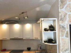 スペタルにあるHoliday Home Pavarotti-Three Bedroom Holiday Home with Terraceの石壁のキッチン(白いキャビネット付)