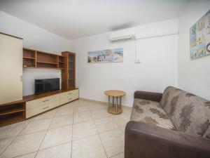 ein Wohnzimmer mit einer Couch, einem Fernseher und einem Tisch in der Unterkunft Villa Dvori Vi kovi-Seven Bedroom Villa with Swimming Pool in Podstrana