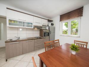 eine Küche mit einem Holztisch, einem Tisch und einem Tisch in der Unterkunft Villa Dvori Vi kovi-Seven Bedroom Villa with Swimming Pool in Podstrana