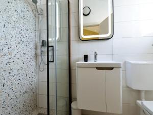 a bathroom with a shower and a sink and a mirror at Apartments Helena - One bedroom apartment with Balcony and Sea View - A1 in Murter
