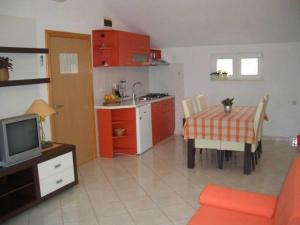 a kitchen and dining room with a table and a television at Apartment in Bol with balcony in Bol