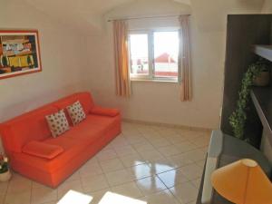 a living room with an orange couch and a window at Apartment in Bol with balcony in Bol