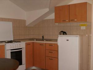 a kitchen with a white refrigerator and wooden cabinets at Apartment Luna - One Bedroom Apartment with Terrace and Sea View Molunat in Molunat