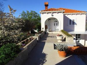 a white house with a pathway leading to a door at Apartment Marita - One Bedroom Apartment with Balcony in Čilipi