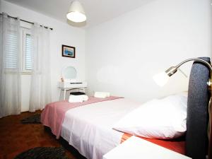a bedroom with two beds and a lamp and a mirror at Apartment Marita - One Bedroom Apartment with Balcony in Čilipi
