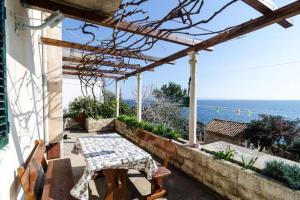 a patio with a table and a view of the ocean at Holiday Home Jasminka - Three Bedroom Holiday Home with Terrace and Sea View in Potomje