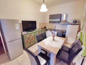 una cucina con tavolo, sedie e frigorifero di Bertie's Lodge - Four Bedroom Apartment A4 a Smokvica
