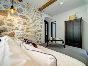 a bed in a room with a stone wall at History House Moja Ti 1830 - Deluxe Apartment Gorica in Senj