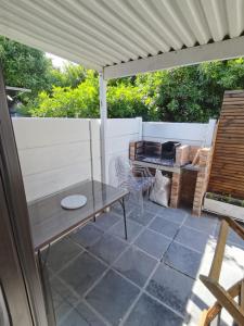 a patio with a wooden table under a white umbrella at Spanish Villa- Pet Friendly in Cape Town