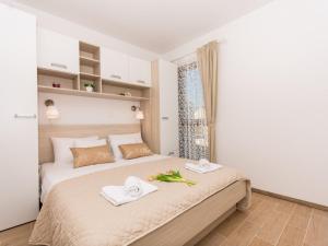 a bedroom with a bed with towels on it at Villa LA-Comfort One Bedroom Apartment with Sea View Terrace 1 in Veliki Drvenik